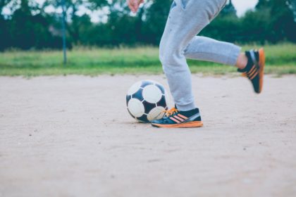 boy running with soccer ball in blog about soccer injuries, and how physical therapy can help