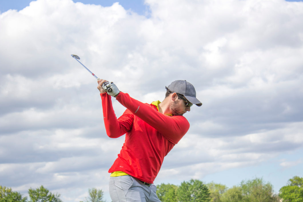 Man in red shirt golfing