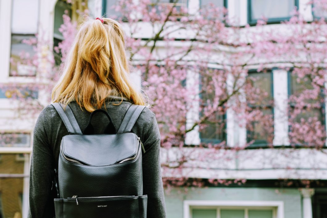 Woman carrying black leather backpack