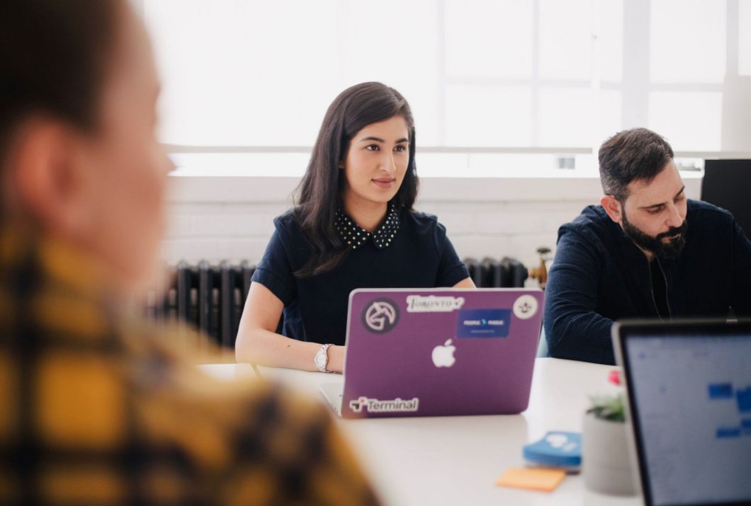 Woman at a purple laptop amongst study group