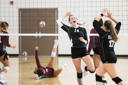 Female Volleyball team celebrates while opponent falls to the ground and might have a concussion