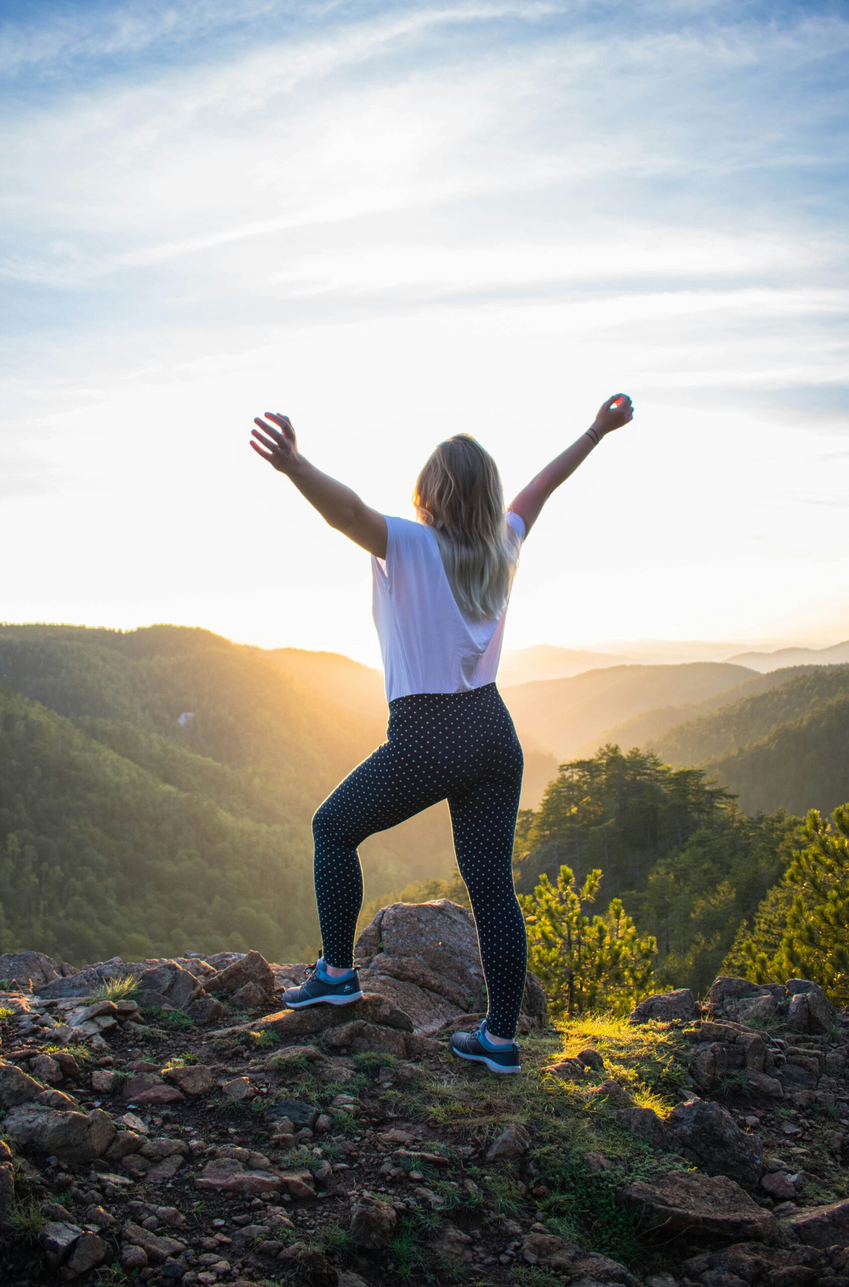 Person celebrating their Physiotherapy completion with a hike in front of a sunrise